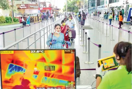  ?? — PTI ?? Passengers undergo thermal scanning on their arrival at Kempegowda Internatio­nal Airport in Bengaluru on Monday. The domestic passenger flight operations resumed after a gap of two months, owing to nationwide Covid-19 lockdown.