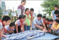  ?? ZHANG DUAN / XINHUA ?? Attentive children learn first-aid techniques for drowning victims with the guidance of a doctor in Hefei, Anhui province, on Wednesday. The city’s Wulidun Community Health Center launched a first-aid education session for primary school students...