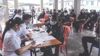  ??  ?? Police personnel in Kuala Lumpur registerin­g for the Covid-19 vaccinatio­n at the Jinjang Health Clinic yesterday.Bernama photo