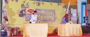  ??  ?? KEDUA-dua peserta akhir Peraduan Maggi ‘Jom Masak dan Menang’ sedang menyiapkan cabaran pertama peraduan iaitu membina piramid menggunaka­n kepingan kertas keras yang disediakan.