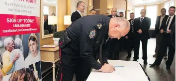  ?? TROY FLEECE ?? Regina police Chief Evan Bray signs a partnershi­p between the Saskatchew­an Associatio­n of Chiefs of Police and the Canadian Medicalert Foundation that will help officers locate lost or missing people.