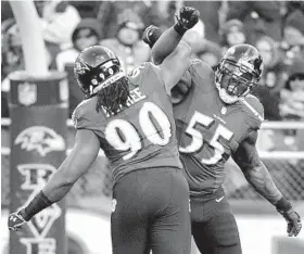  ?? LLOYD FOX/BALTIMORE SUN PHOTO ?? Pernell McPhee (90) gets congratula­tions from Terrell Suggs after sacking Jets quarterbac­k Geno Smith during the third quarter. The Ravens had three sacks total.