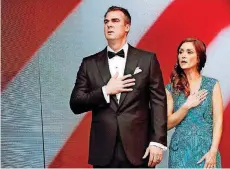  ?? [PHOTO BY NATE BILLINGS, THE OKLAHOMAN] ?? Gov. Kevin Stitt and his wife, Sarah Stitt, say the Pledge of Allegiance during the inaugural ball for Stitt at the Cox Convention Center in Oklahoma City on Monday night.