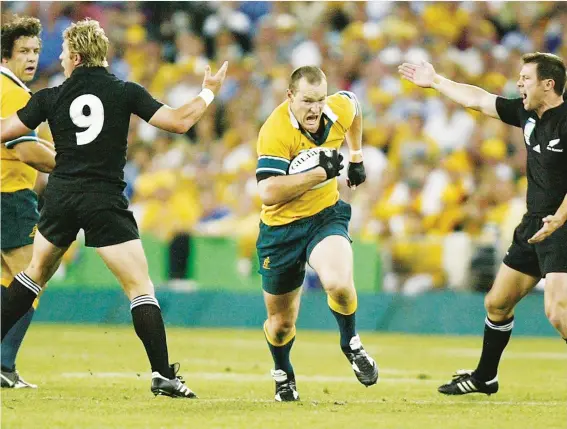  ??  ?? Winner on the big stage: Stirling Mortlock breaks the All Blacks line as Eddie Jones orchestrat­es Australia’s win over New Zealand in the 2003 World Cup