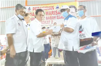  ??  ?? Shafie signing the plaque for the multipurpo­se hall at Kampung PPRT Sabah Baru Peringkat II.