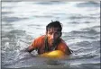  ?? BERNAT ARMANGUE THE ASSOCIATED PRESS ?? Rohingya Muslim Abdul Karim, 19, uses a yellow plastic oil container as a flotation device as he swims the Naf River on Nov. 4.