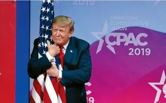  ?? AP ?? President Donald Trump hugs the American flag as he arrives to speak at Conservati­ve Political Action Conference, CPAC 2019, in Oxon Hill, Maryland.