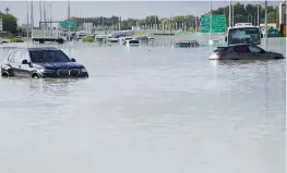  ?? — AP ?? Vehicles stuck in floodwater covering a major road in Dubai on Wednesday. Heavy thundersto­rms lashed the United Arab Emirates on Tuesday, dumping over a yearand-a-half worth of rain on the desert city-state of Dubai in the span of hours.