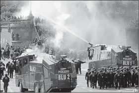  ?? AP/MATTHIAS SCHRADER ?? Police use water cannons to clear protesters from a road Friday in Hamburg, Germany.