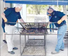  ?? Westside Eagle Observer/MIKE ECKELS ?? A pair of chicken flippers remove the top grate to expose perfectly cooked chicken, the star of the 67th Decatur Barbecue at Veterans Park in Decatur Aug. 7. The chicken cooking crew began cooking the halves, donated by Simmons Foods, around 7 a.m., with the first orders coming in around 10 a.m.