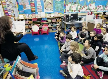  ?? PIERRE OBENDRAUF/ THE GAZETTE ?? Bancroft school teacher Josie Sabelli reads during storytelli­ng time in kindergart­en class on Monday.
