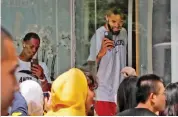  ?? — AP ?? NBA players use their smartphone­s to film fans gathers outside a hotel in Shanghai on Thursday.