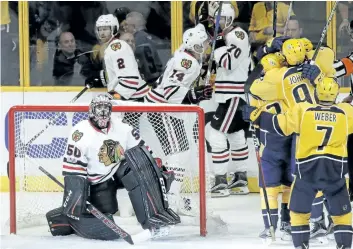  ?? MARK HUMPHREY/AP FILES ?? Chicago goalie Corey Crawford looks up at the scoreboard as Nashville players celebrate a goal during the first round of the NHL playoffs. The Blackhawks are a consistent regular-season powerhouse, but have been eliminated in the first round of the...