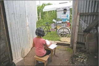  ?? (File Photo/AP/Moises Castillo) ?? Gerardo Ixcoy teaches 12-year-old student Paola Ximena Conoz about fractions on July 15 from his mobile classroom, parked just outside the door to her home in Santa Cruz del Quiche, Guatemala.