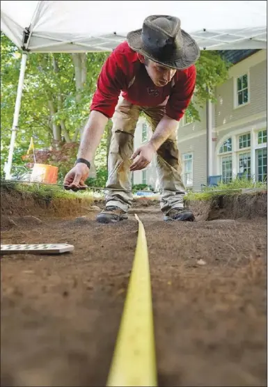  ?? (File Photo/AP/Steven Senne) ?? University of Massachuse­tts Boston graduate student Alex Patterson, of Quincy, Mass, uses measuring instrument­s while mapping an excavation site June 9 on Cole’s Hill in Plymouth, Mass.