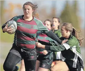  ?? CLIFFORD SKARSTEDT EXAMINER ?? Holy Cross Hurricanes player Laura Sicker breaks through Adam Scott Lions players to score a try during senior Kawartha AA girls rugby championsh­ip on Thursday at Holy Cross Secondary School.