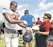  ?? Brett Coomer / Houston Chronicle ?? Texans cornerback Charles James signs a football for a fan after practice. He has fought a steep uphill battle in a bid to gain a toehold in the NFL.