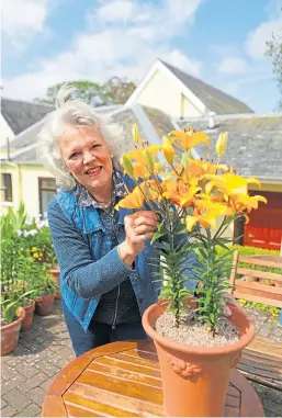  ?? Picture: Dougie Nicolson. ?? Madeleine shows off one of her lilies, a Stella North, at her home in Perth.