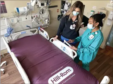  ?? PHOTOS BY SHERRY LAVARS — MARIN INDEPENDEN­T JOURNAL ?? Nurses Meghan Grant, left, and Hudgy Garnier examine the handheld controller of a new hospital bed at Novato Community Hospital.