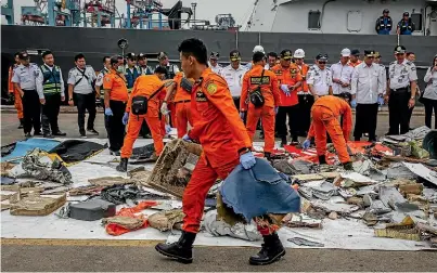  ?? GETTY IMAGES ?? Search and Rescue personnel examine recovered debris and personal items from Lion Air flight JT 610 at the Tanjung Priok port in Jakarta.