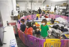  ?? Dario Lopez-Mills / Associated Press ?? Unaccompan­ied migrants, ages 3 to 9, watch TV inside a playpen in March at a detention facility in Donna, Texas.