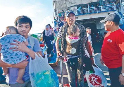  ?? SUNSTAR FOTO / AMPER CAMPAÑA ?? ARRIVAL. Cebu City Councilor Dave Tumulak (right) welcomes the evacuees from conflict-torn Marawi City.