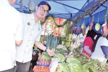  ??  ?? Junz visiting one of the booths at the Cabbage Festival in Kundasang.