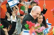  ?? AP FILE PHOTO ?? Then Israeli president Shimon Peres hugs children during a welcoming ceremony held by President Xi Jinping at the Great Hall of the People in Beijing on April 8, 2014.