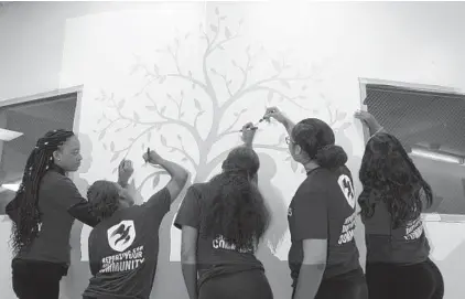  ?? ALGERINA PERNA/BALTIMORE SUN ?? Members of the Alpha Kappa Alpha Sorority from Towson University trace a mural at Roots and Branches School in Harlem Park. From left are Ngafla Bakayoko, Darre'll Joseph, Ashley Britton, Lia Johnson and Jasmine Ward.