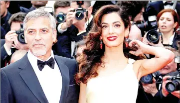 ??  ?? Clooney and Amal pose on the red carpet as they attend the 69th Cannes Film Festival in Cannes, France, on May 12, 2016.