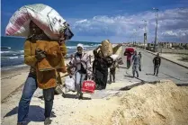  ?? FATIMA SHBAIR/ ASSOCIATED PRESS ?? Palestinia­ns flee Gaza City to the southern Gaza Strip, in Wadi Gaza, on Monday.