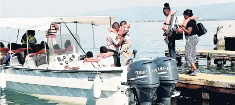  ?? PHOTO BY CHRISTOPHE­R SERJU ?? This youngster gets a much-needed helping hand to get into the boat as his teachers watch. They went on a boat tour of the mangroves after visiting the biodiversi­ty centre and hearing a presentati­on about the impact and importance of mangroves.