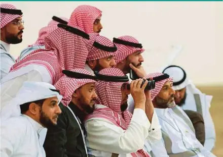  ?? AFP PIC ?? Saudi men looking to spot the first crescent of the moon marking the start of Ramadan, in the southern Saudi city of Hautat Sudair, on Sunday.
