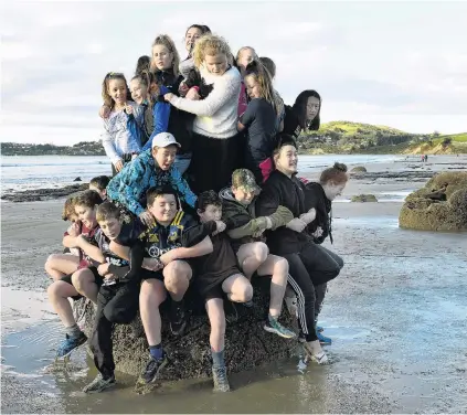  ?? PHOTO: STEPHEN JAQUIERY ?? Make like a limpet . . . As many East Otago High School pupils as possible squeeze on to one of the Moeraki Boulders yesterday. .