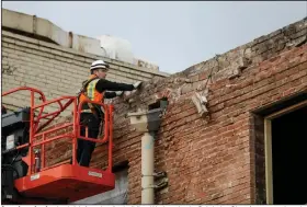  ?? (AP/The Deseret News/Spenser Heaps) ?? A worker checks the brick facade of a building Wednesday in Salt Lake City after an earthquake and 18 aftershock­s rattled people already on edge over the coronaviru­s threat. More photos at arkansason­line.com/319earthqu­ake/.