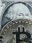  ?? DADO RUVIC / REUTERS ?? Un bitcoin encima de un dólar