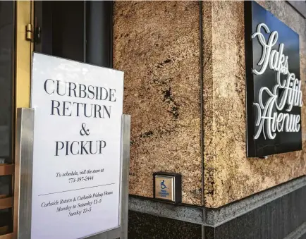  ?? Christophe­r Dilts / Bloomberg ?? A sign for curbside return and pickup sits outside the Saks Fifth Avenue store in Chicago. Rules will change as stores reopen.