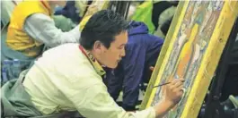  ?? PALDEN NYIMA / CHINA DAILY ?? Artists in Tibet draw thangka paintings on-site at the expo.