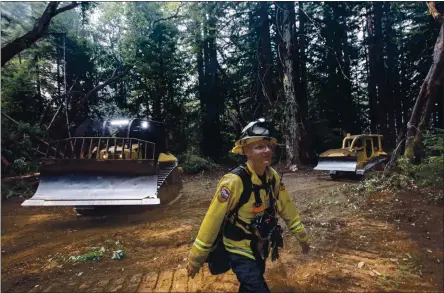  ?? KARL MONDON — STAFF PHOTOGRAPH­ER ?? Scott Bullock, a Cal Fire forester, directs bulldozers creating a second firebreak behind UC Santa Cruz as a defense against the CZU Lightning Complex Fire in Santa Cruz on Saturday. Bullock said the devastatio­n he saw in Boulder Creek and Bonny Doon would stay with him for a long time.