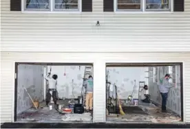  ?? LAUREN LANCASTER/ THE NEW YORK TIMES ?? Painters work on the garage at Eduardo Hermosilla’s home in Poughkeeps­ie, N.Y., last week, where he is preparing for a socially distanced, open-air Thanksgivi­ng dinner with his daughter, an epidemiolo­gist, and her family.