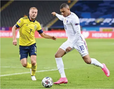  ?? AFP ?? France’s forward Kylian Mbappe and Sweden’s midfielder Sebastian Larsson vie for the ball during the UEFA Nations League football match at the Friends Arena in Solna, near Stockholm.