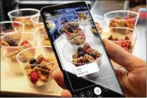  ?? RICHARD DREW / ASSOCIATED PRESS ?? The Samsung Galaxy S9’s Bixby virtual assistant allows the smartphone’s user to identify food on a table and supply its nutritiona­l informatio­n.