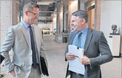  ?? [DORAL CHENOWETH III/DISPATCH] ?? Columbus Firefighte­r Mark Rine, left, smiles with his attorney, Jonathan Goodman, after learning that the city had dropped its challenge to his line-of-duty benefit claim. They were at the Ohio Bureau of Worker’s Compensati­on offices Thursday.