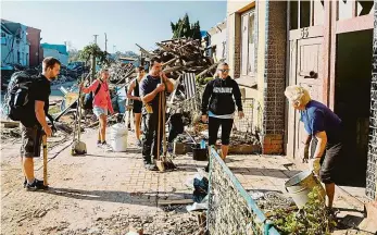  ?? Foto: Petr Topič, MAFRA ?? Potřebujet­e něco? Dobrovolní­ci s nářadím obcházejí domy ve vesnici Hrušky a ptají se, kde mají pomáhat. Ne všude ale uspějí.