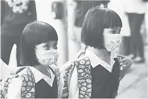  ?? — Gambar Bernama ?? NORMA BAHARU: Kelihatan dua murid kembar memakai pelitup muka ketika hadir ke sekolah seawal jam 7 pagi di Sekolah Kebangsaan (P) Sultan Ibrahim, Johor Bahru semalam.