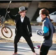  ?? Marie D. De Jesús / Houston Chronicle ?? Rodger Shull, barefoot but dressed in a suit, cheers for a half marathon runner. The thermomete­r read 34 degrees at 7 a.m. Sunday.