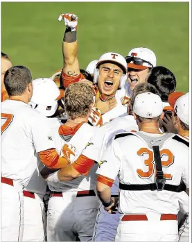  ?? SUE OGROCKI / ASSOCIATED PRESS ?? Tres Barrera (center) is mobbed by teammates after his single in the ninth put the Horns one win from reaching the Big 12 tourney championsh­ip game.