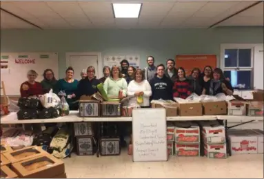  ?? PHOTO PROVIDED ?? Volunteers help make food baskets for Thanksgivi­ng.