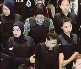  ?? FILE PIC ?? Police officers bringing the suspects, Siti Aisyah (front row, centre) and Doan Thi Huong (second row, centre), to the scene of the crime at the Kuala Lumpur Internatio­nal Airport 2 on Oct 24 last year.