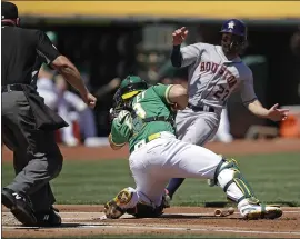  ?? BEN MARGOT — THE ASSOCIATED PRESS ?? On a throw home from A’s right fielder Chad Pinder, the Astros’ Jose Altuve, right, is tagged out by catcher Josh Phegley in the first inning of Sunday’s game in Oakland.